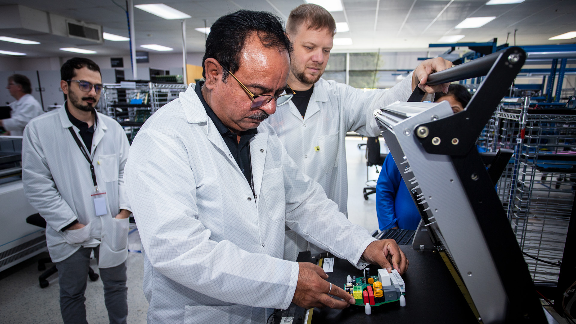 Box Build process at Variosystems: A technician carefully inserts a circuit board into a dedicated assembly station.